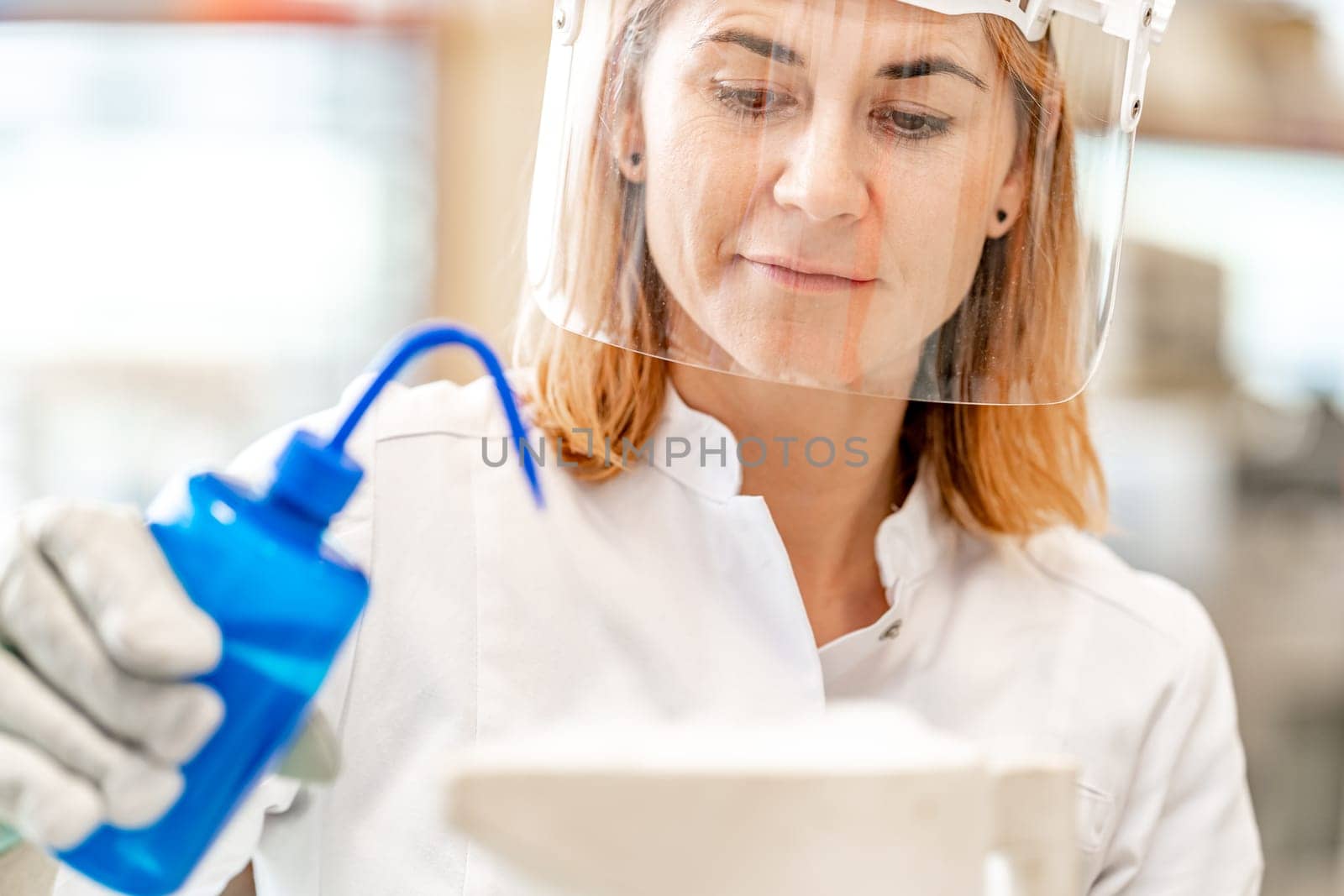 woman in mask, student of the university' science faculty conducts biochemical research in the laboratory by Edophoto