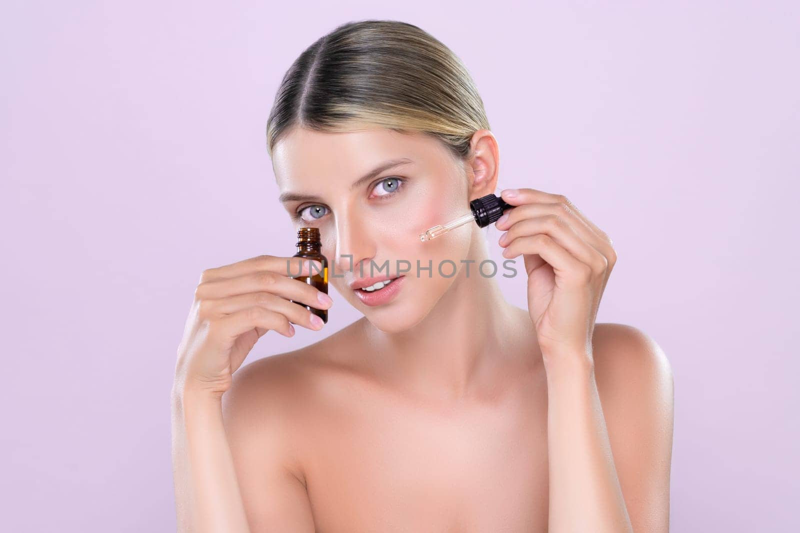 Alluring portrait of beautiful cosmetic skin woman apply extract cannabis oil bottle for skincare product on her face. Cannabis and CBD oil for facial treatment beauty concept. Pink isolated backdrop