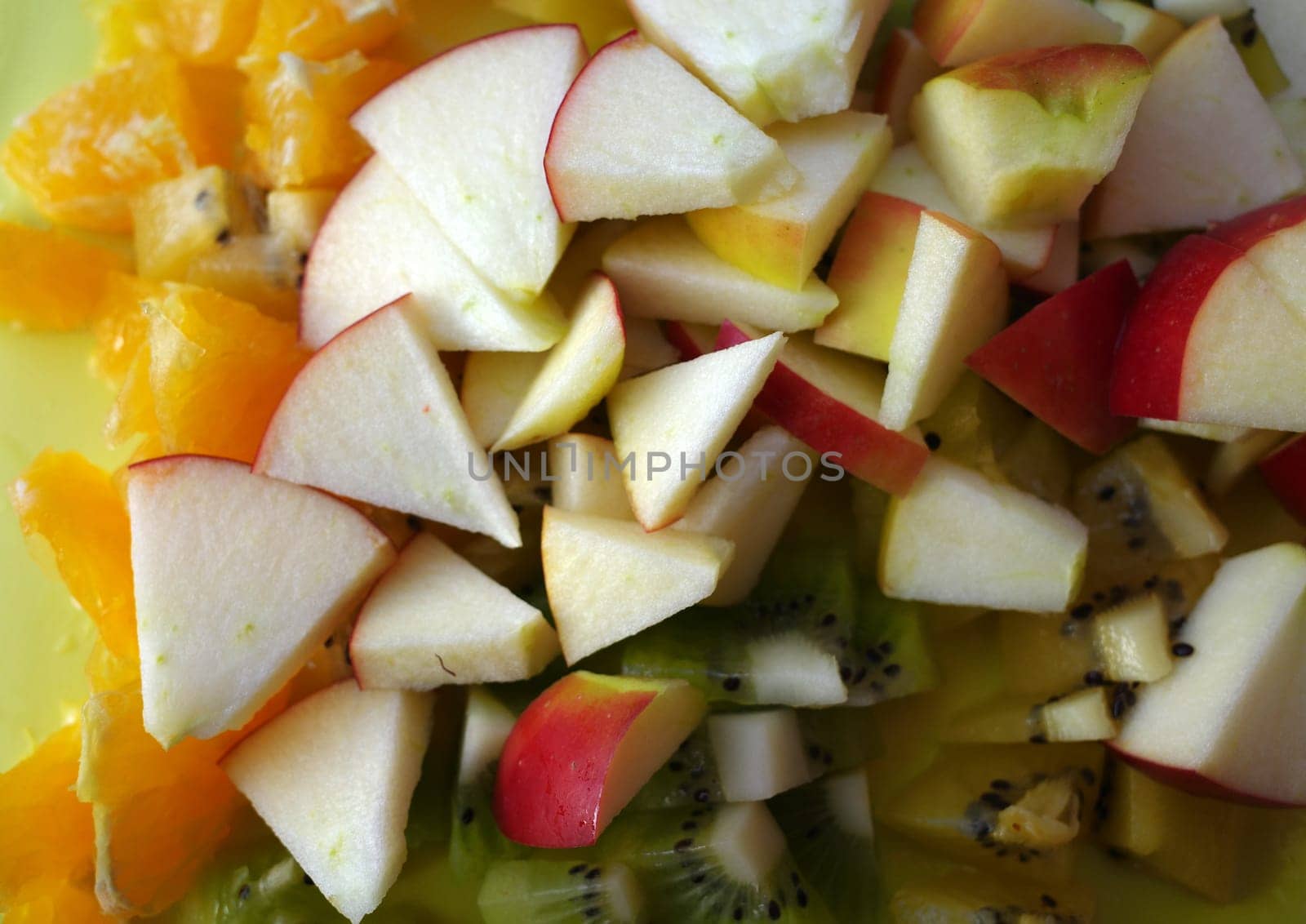 Fresh cut fruit parts. Apple, orange and green kiwi