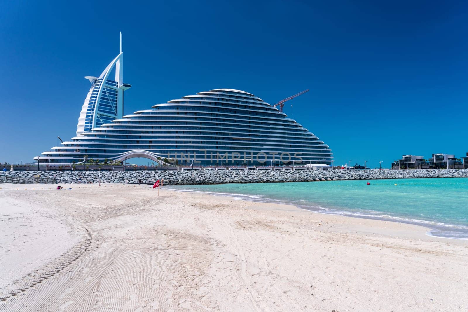 View from Jumeirah public beach of the construction of Marsa al Arab hotel with Burj al Arab behind on coast of Dubai