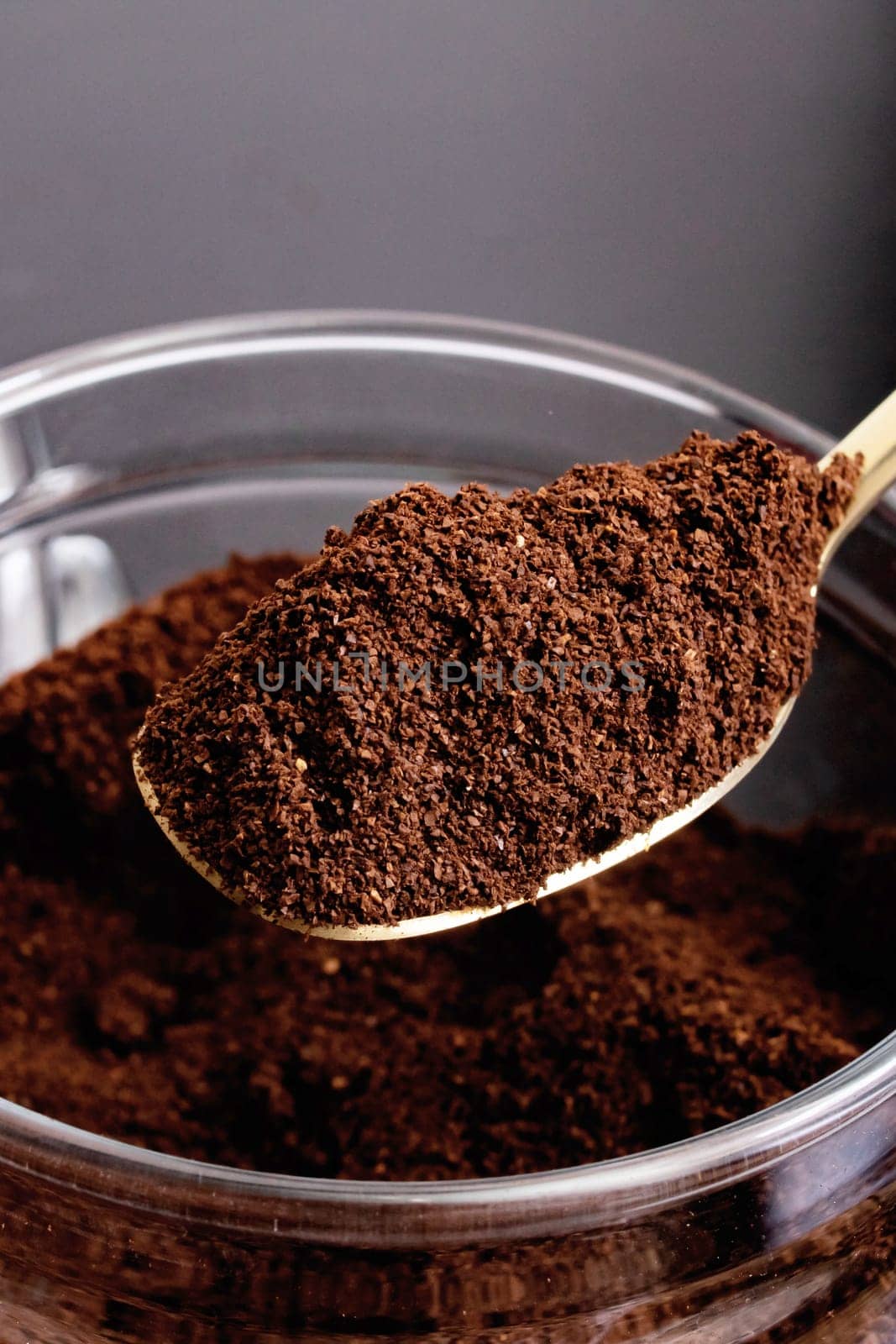 Ground coffee in a glass jar and spoon on the table