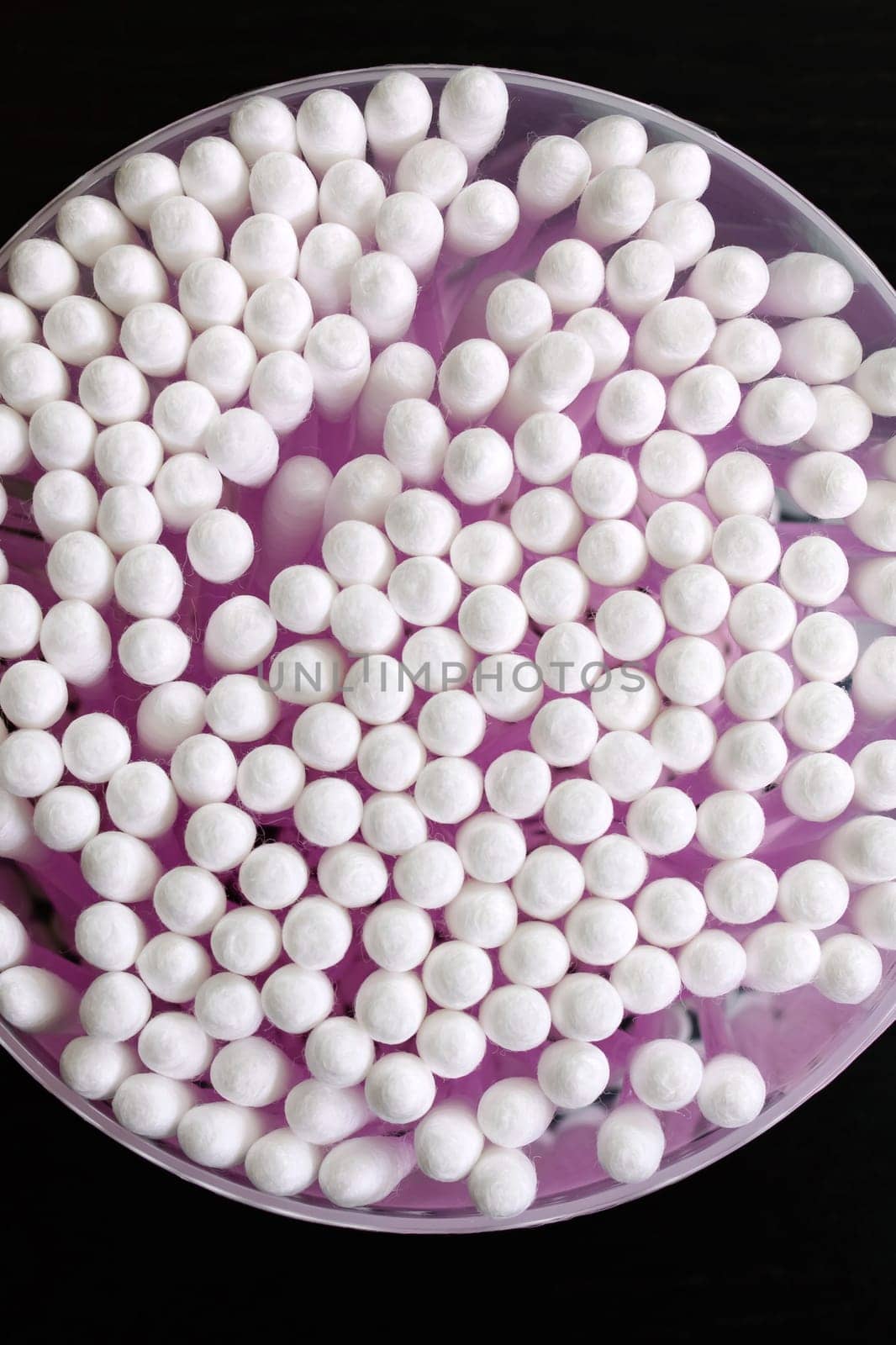 Can with cotton buds on a black wooden background