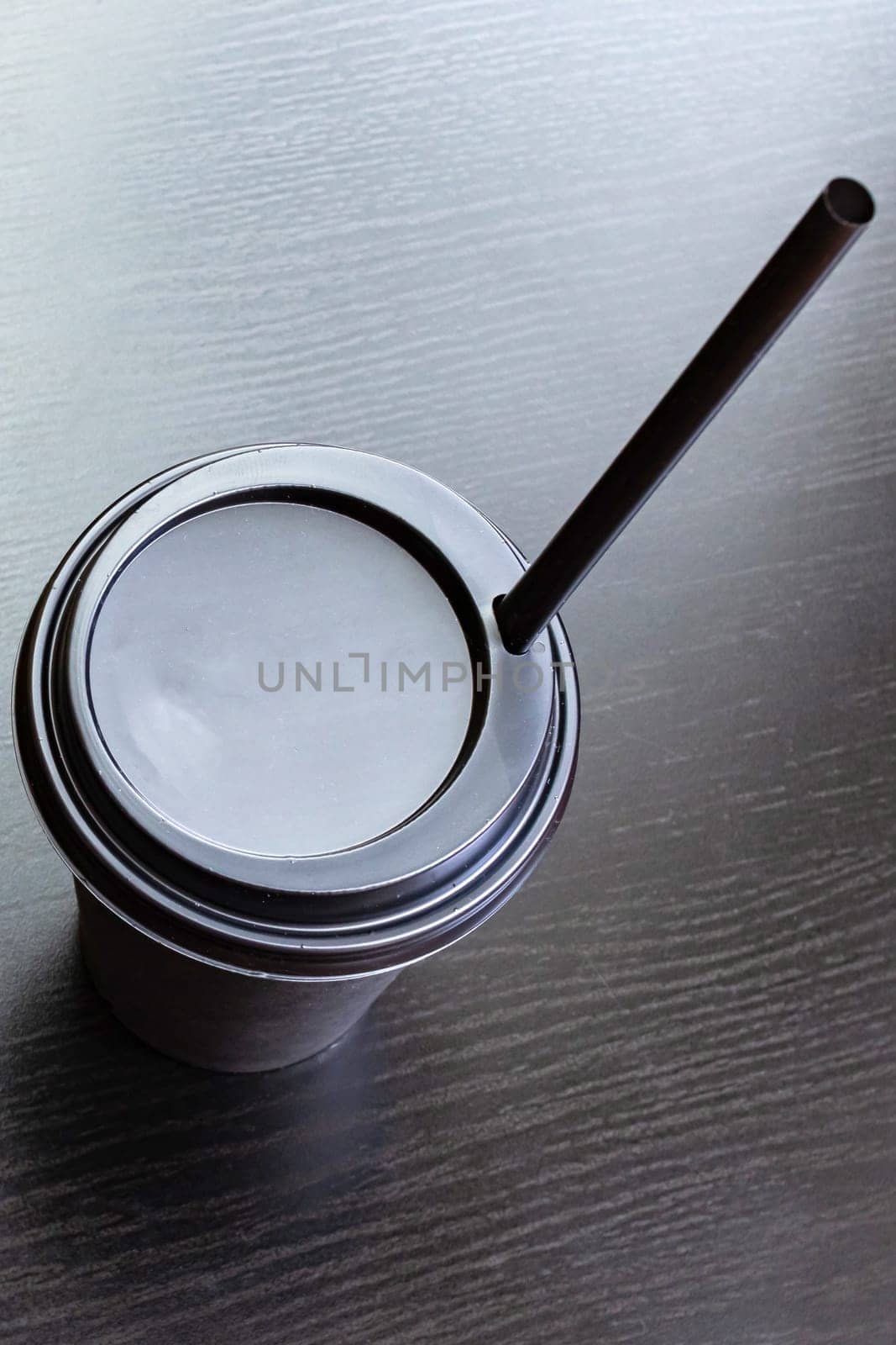Black paper cup of coffee isolated on a wooden table