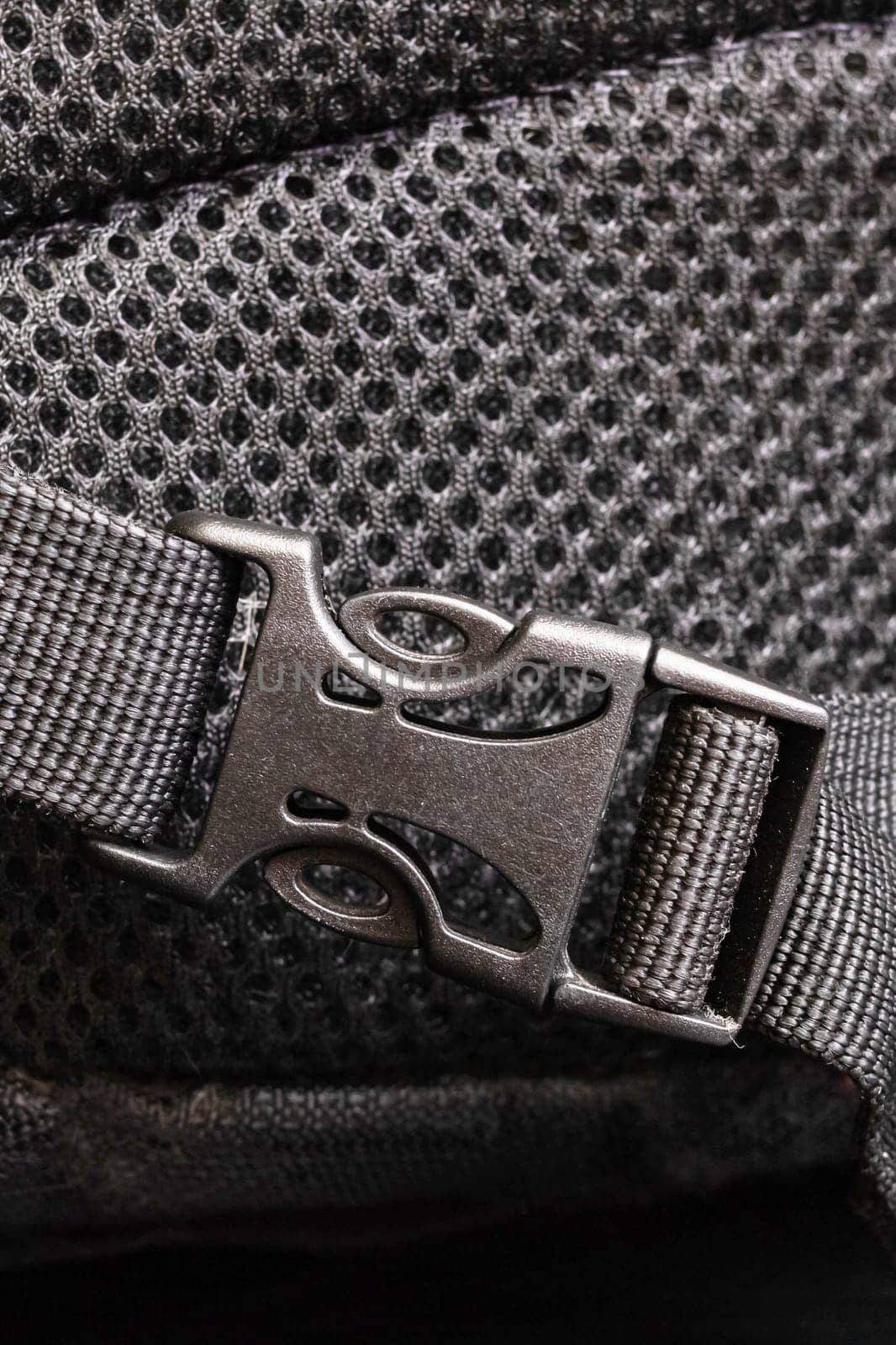 Plastic clasp on a black backpack close up