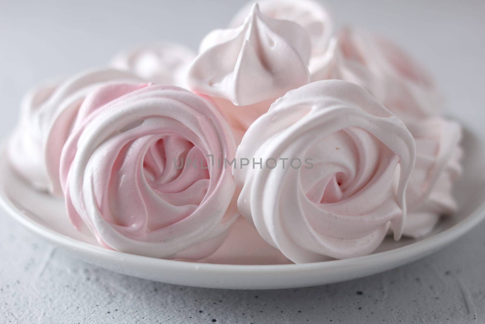 Meringue. Light dessert of whipped egg whites on a gray background. by lara29