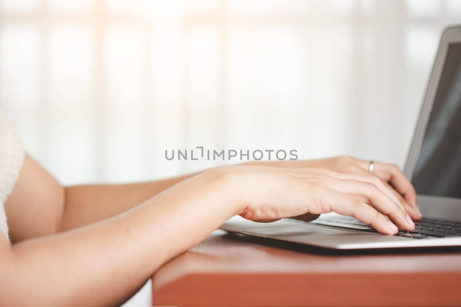 Asian woman's hand using a computer laptop for the concept of business, communication and media technology.