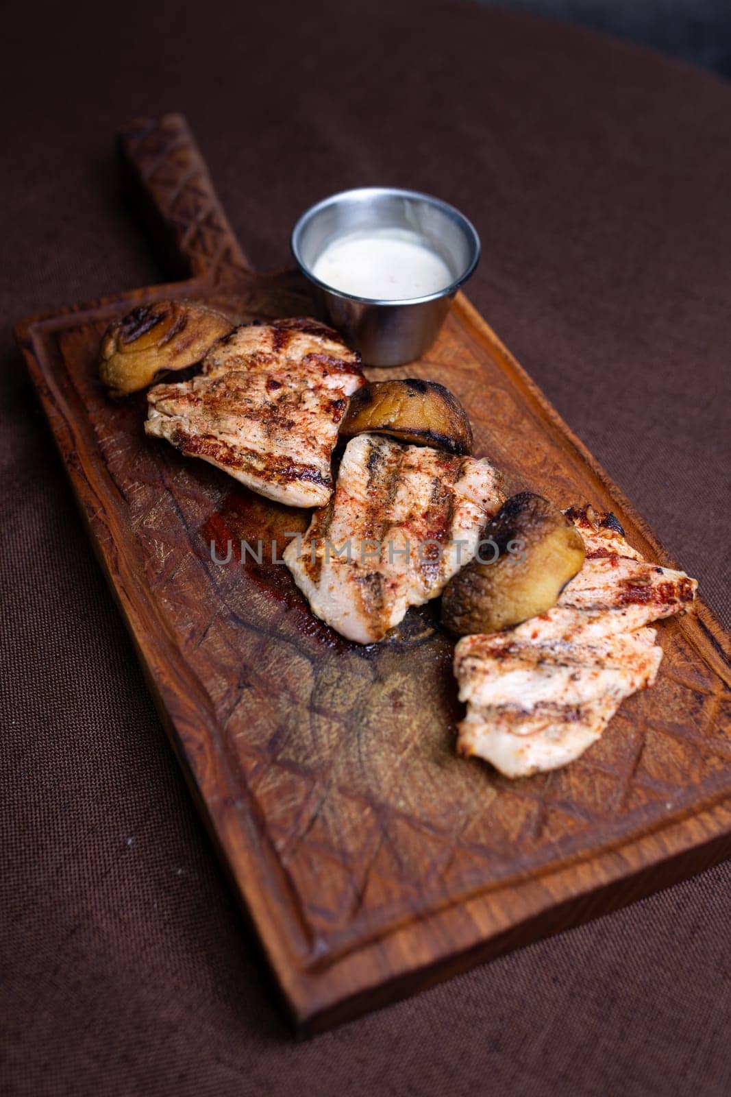 grilled chicken fillet with mushrooms on a wooden board top view by Pukhovskiy