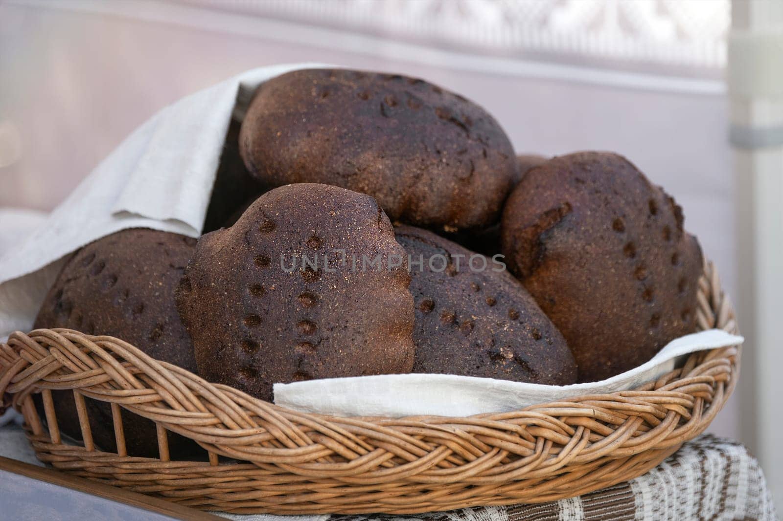 Black fresh homemade bread. A loaf of black rye bread on the counter of a bakery is cut into pieces close-up. Texture of black ecological bread.