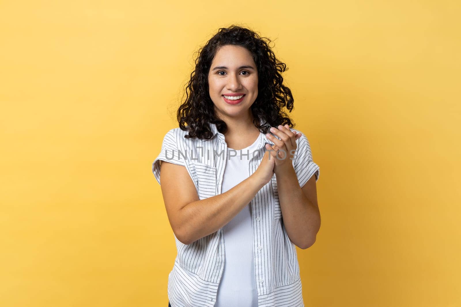 Delighted satisfied woman standing looking at camera with toothy smile, clapping hands. by Khosro1