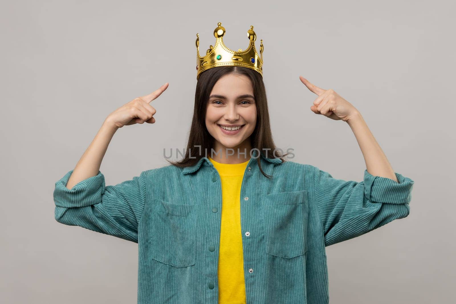 Woman pointing fingers on golden crown on her head, showing her leadership qualities. by Khosro1