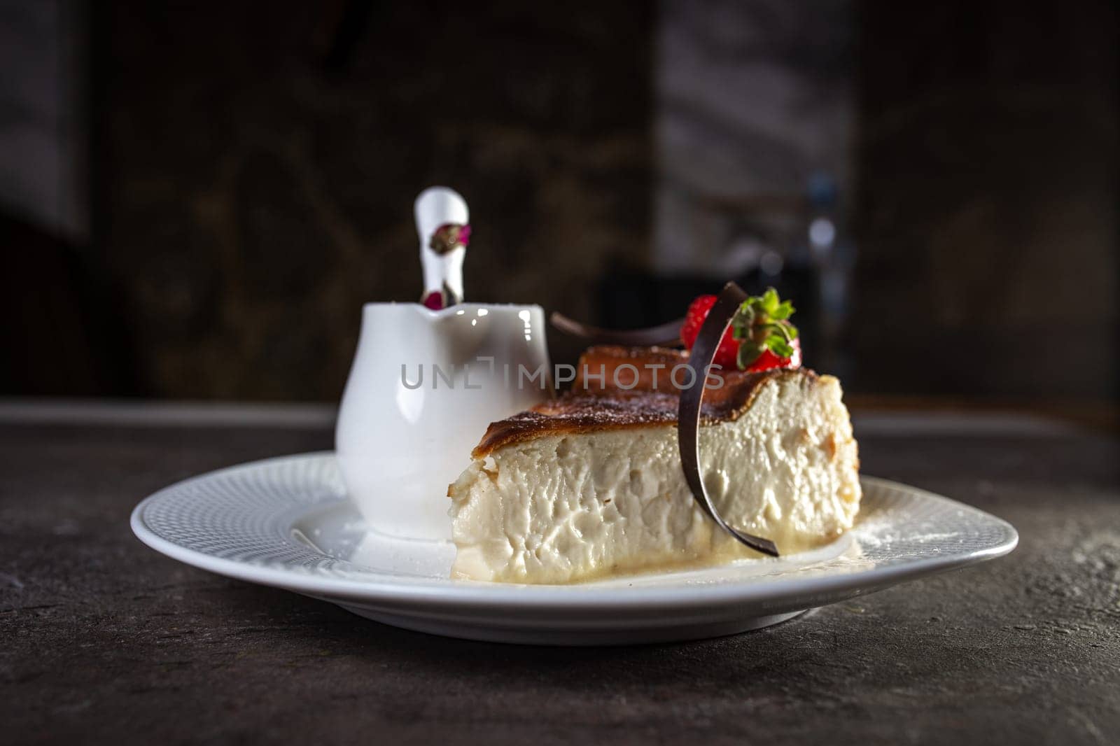 a delicate curd slice of cheesecake with strawberries and condensed milk.