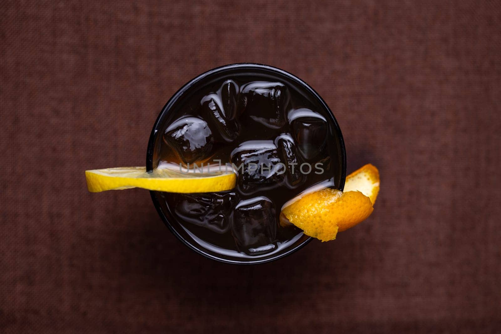 top view alcoholic drink with Cola and a slice of lemon in a glass.