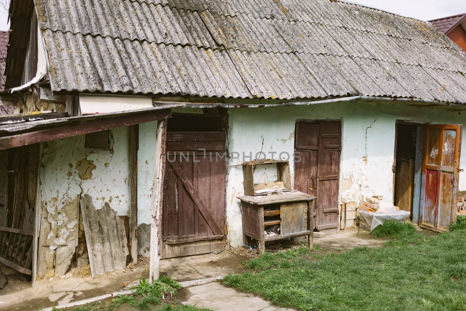 Old abandoned ruined house in dead village. Deserted and destroyed dwelling on farm yard. Neglected building countryside