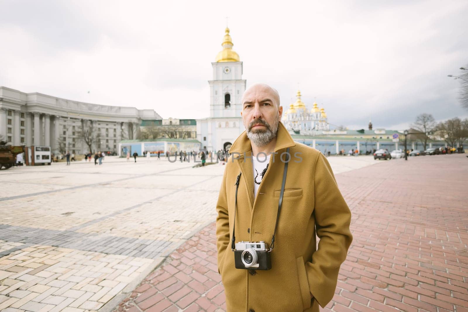 Handsome beard photographer makes pictures on film retro camera in the Kyiv city, Ukraine. by sarymsakov