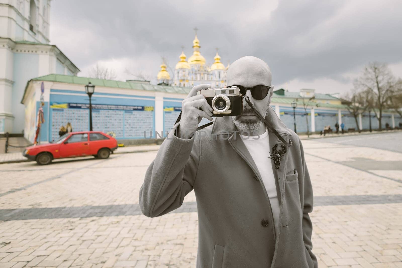 Handsome beard photographer makes pictures on film retro camera in the Kyiv city, Ukraine. by sarymsakov