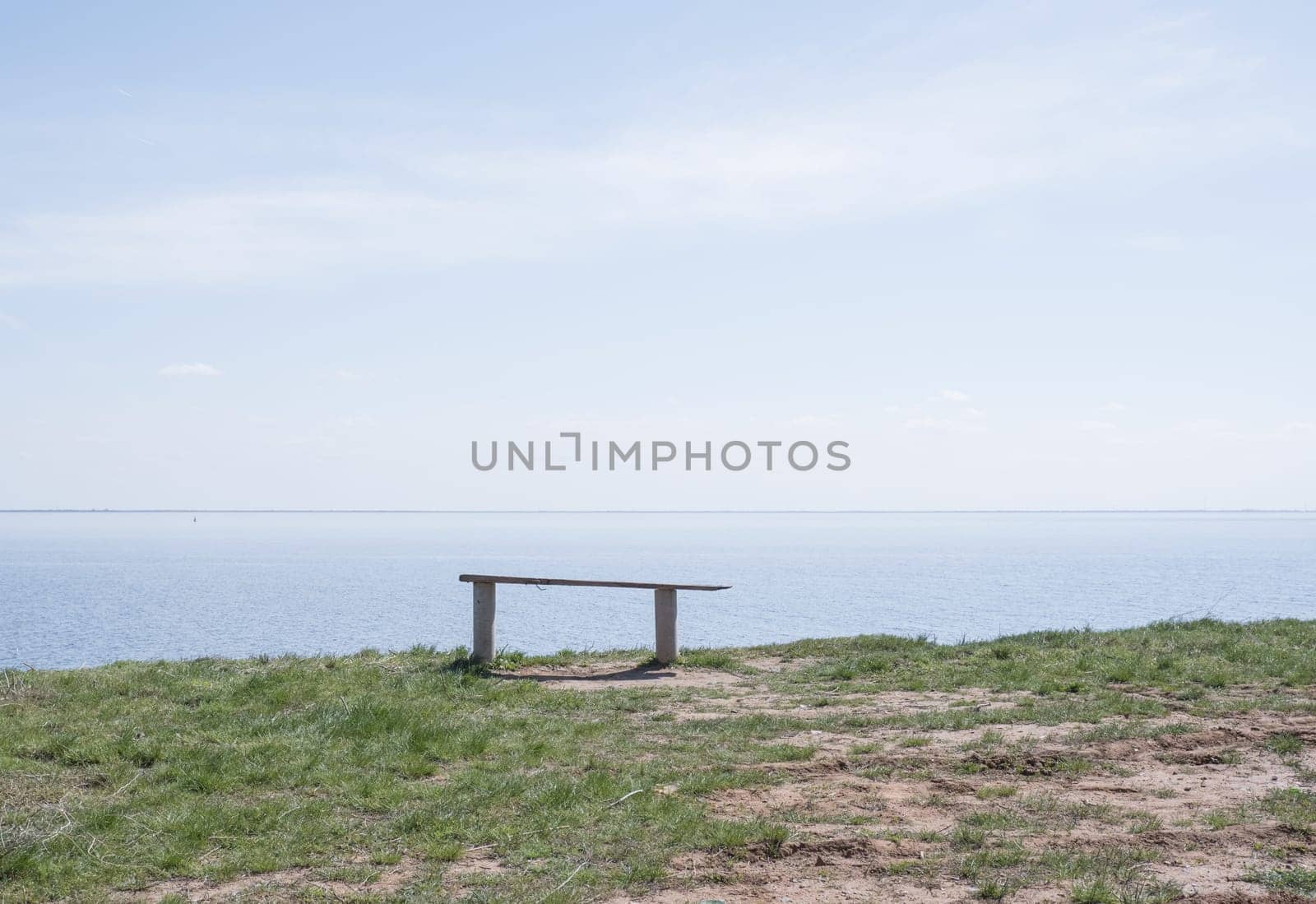 Wooden bench on the shore of the blue sea, lake on a summer sunny day. by Ekaterina34