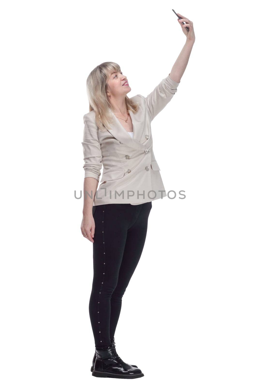 side view. casual woman in a white jacket taking a selfie. isolated on a white background.