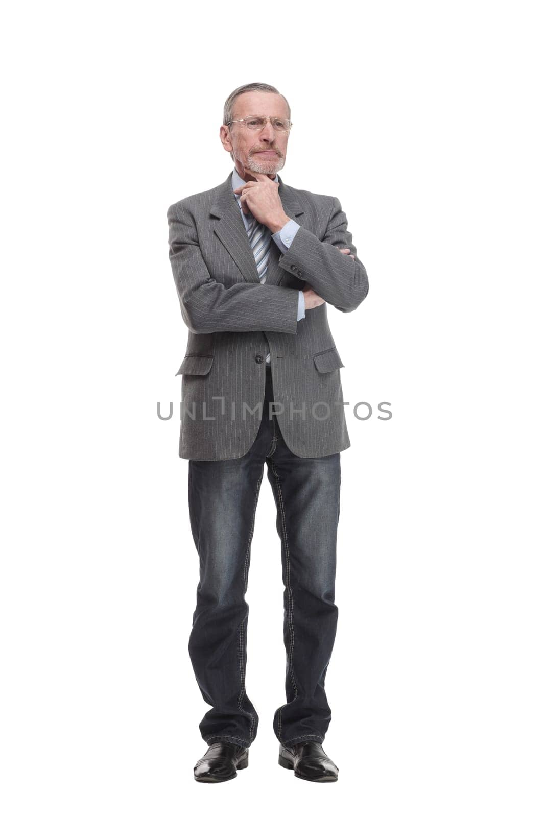 Senior man stands, arms crossed, with one hand on chin in thoughtful full length pose isolated on white