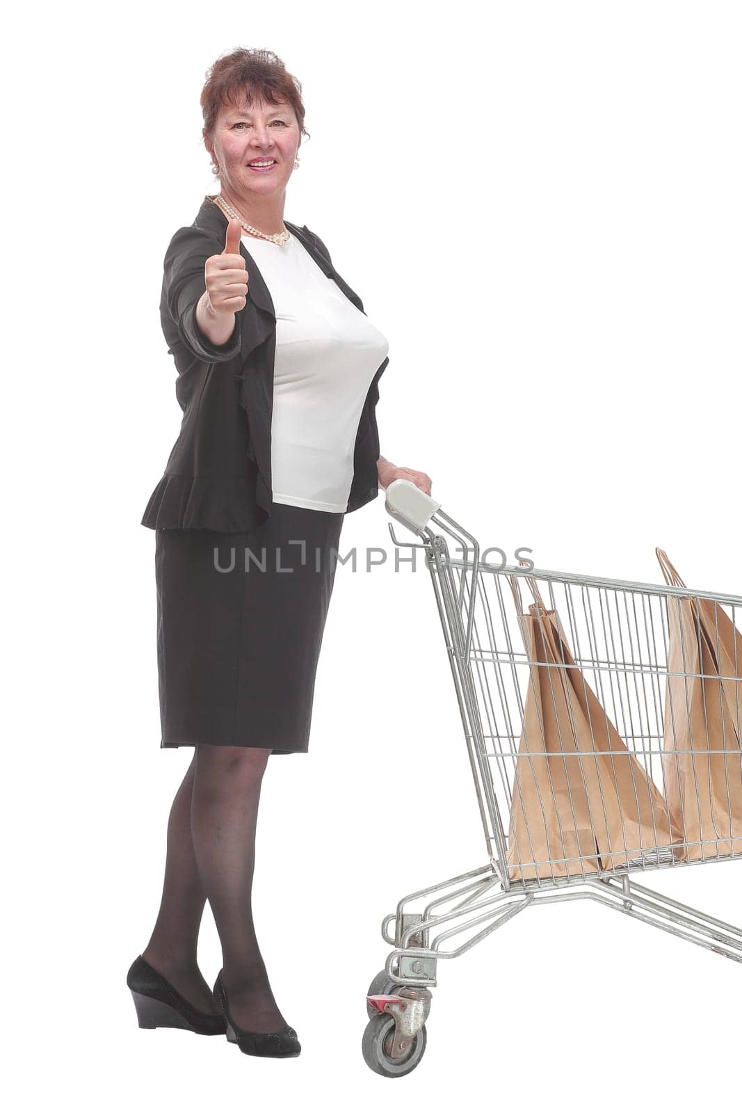 Full length portrait of a woman pushing a shopping trolley isolated on white background