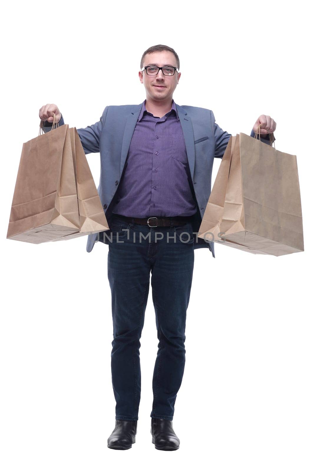 Good looking young man holding shoping bags, standing isolated over white background