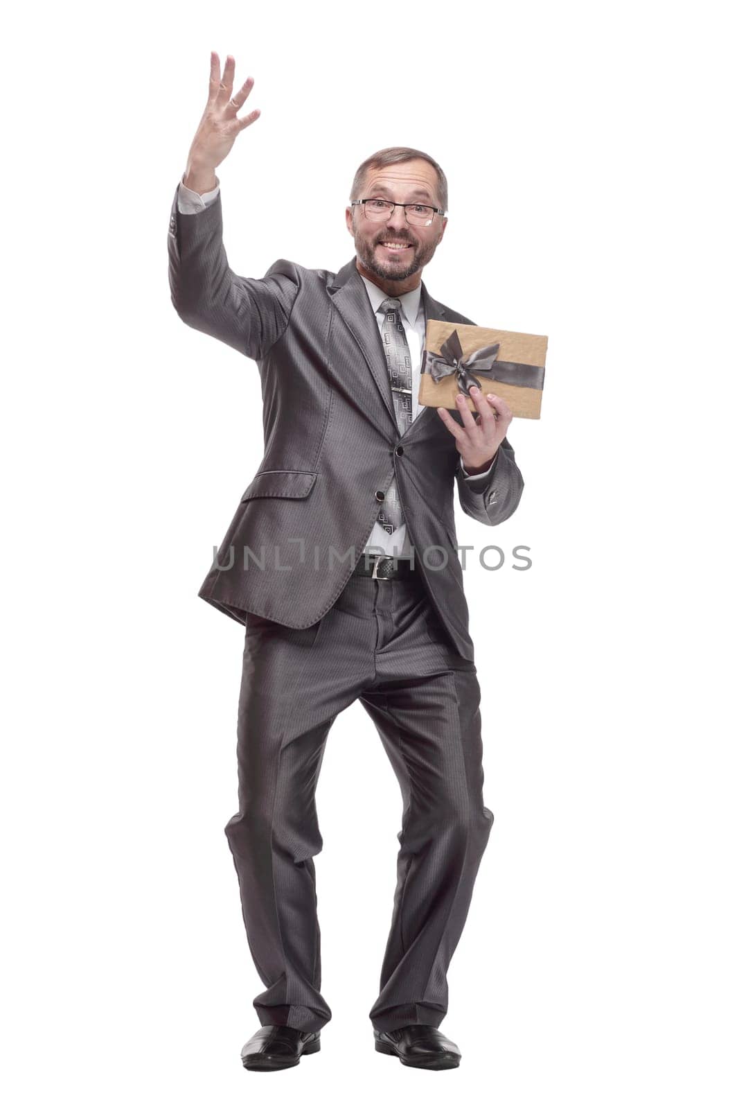 in full growth.happy business man with a gift box. isolated on a white background.