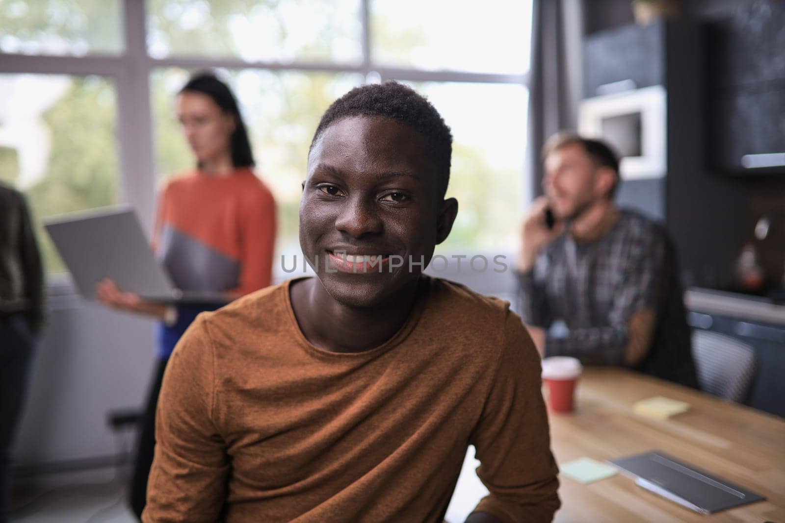 Portrait of happy African American small business owner posing with hands folded
