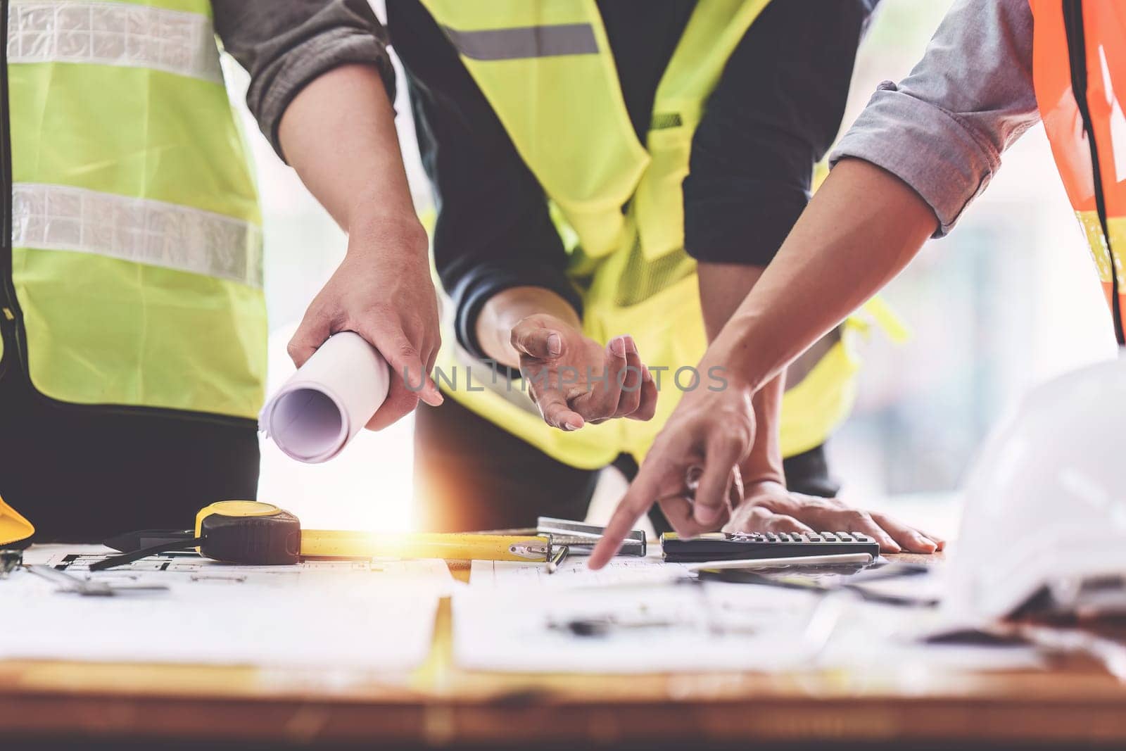 Architect and Engineer working with blueprints for architectural plan, engineer sketching a construction project, green energy concept.