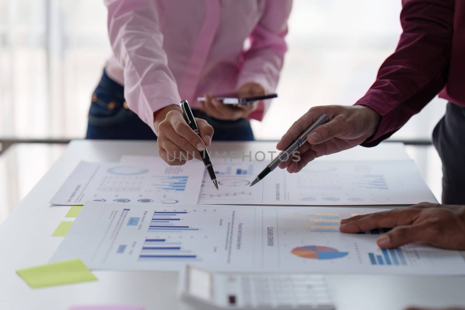 Close up of Diverse colleagues gather brainstorm discuss financial statistics at office meeting. finance, teamwork, Big data Graphs Charts concept.