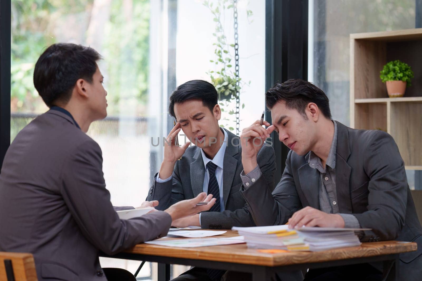 Stressed business person working and research strategy on laptop and looking worried, tired, finance, teamwork, Big data Graphs Charts concept by itchaznong