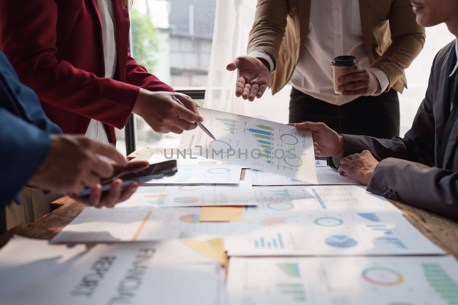 Close up of Diverse colleagues gather brainstorm discuss financial statistics at office meeting. finance, teamwork, Big data Graphs Charts concept.