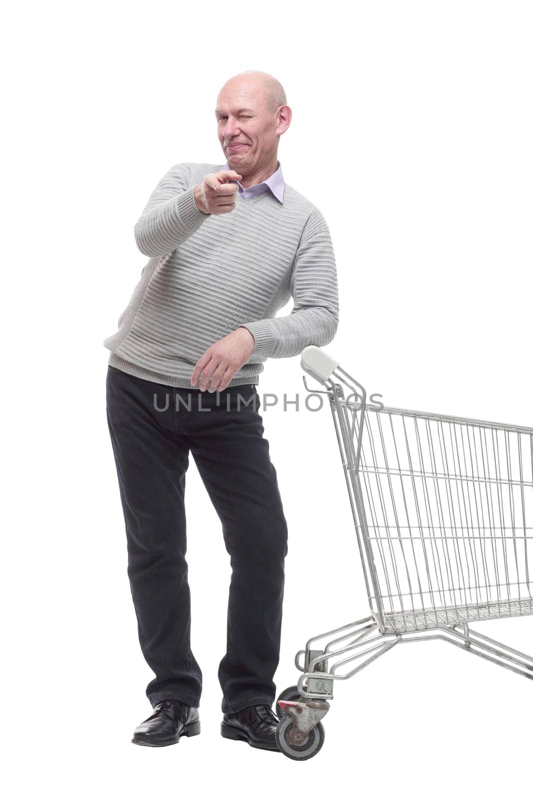 in full growth. a happy man with a shopping cart. isolated on a white background.
