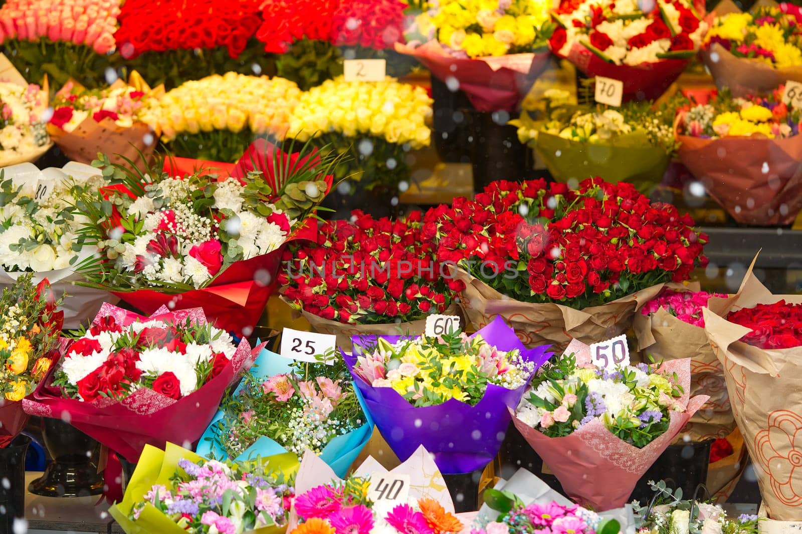 Colorful roses bouquet display in front of flower shop. Flower arrangements for sale at local market. Flowers on sale before mother day, 8 march.