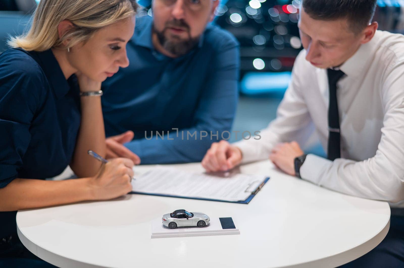 Happy caucasian couple signs a contract for the purchase of a car salon. by mrwed54
