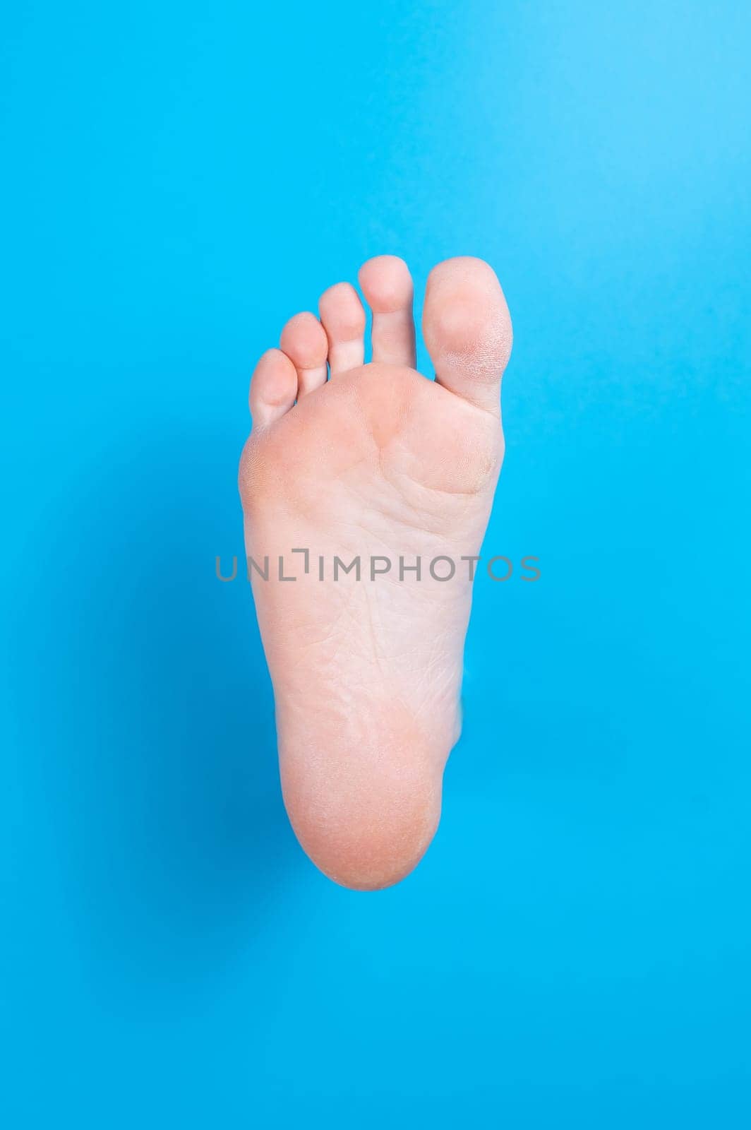 Female bare foot on a blue background