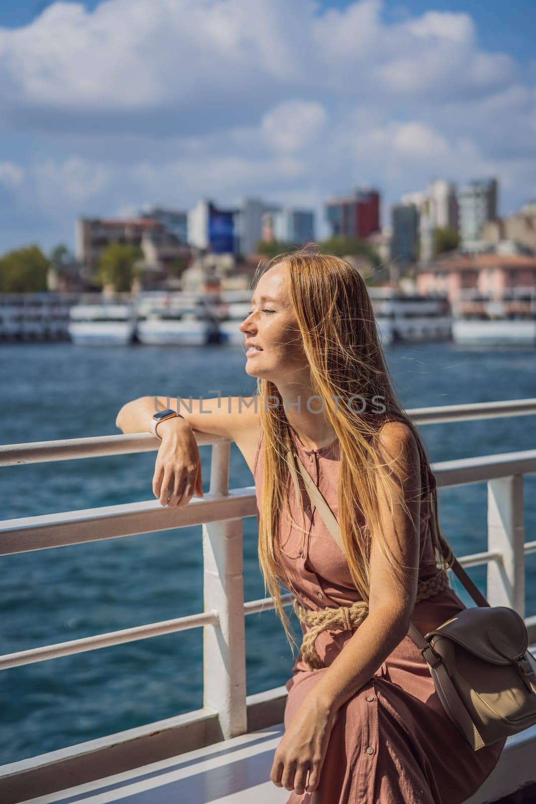 Happy woman enjoying the sea from ferry boat crossing Bosphorus in Istanbul. Summer trip to Istanbul.