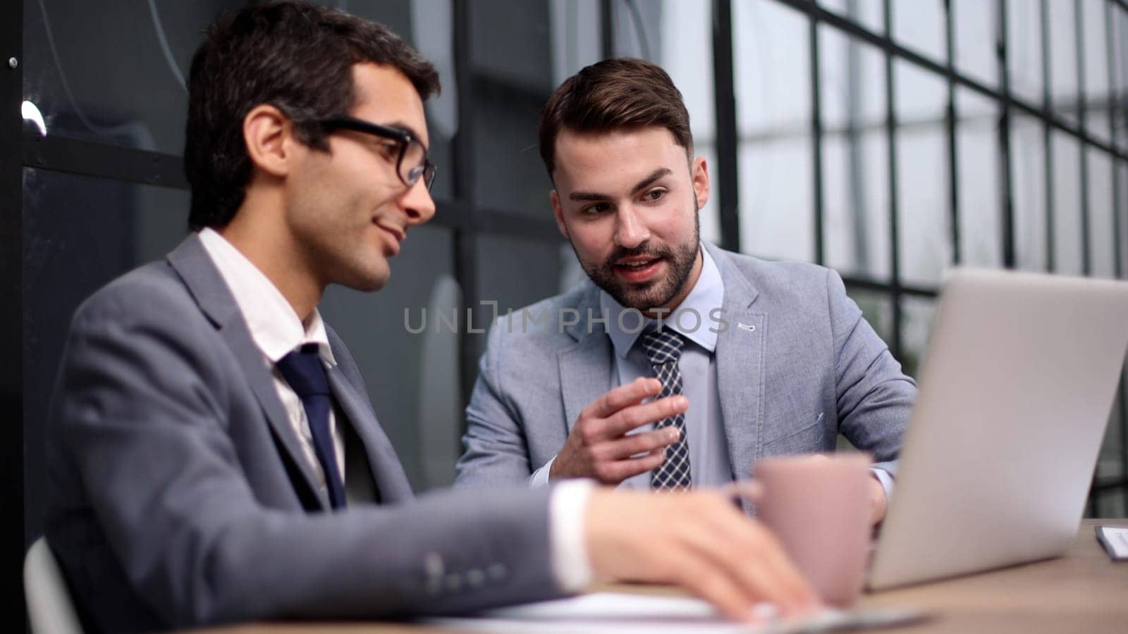 Young designer giving some new ideas about project to his partners in conference room