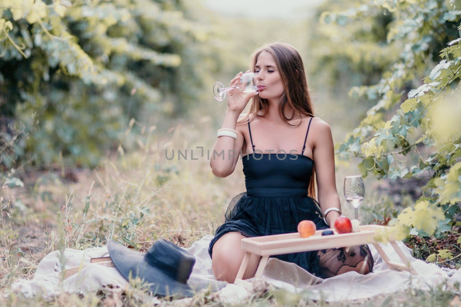 Picnic and wine tasting at sunset in the hills of Italy, Tuscany. Vineyards and open nature in the summer. Romantic dinner, fruit and wine.