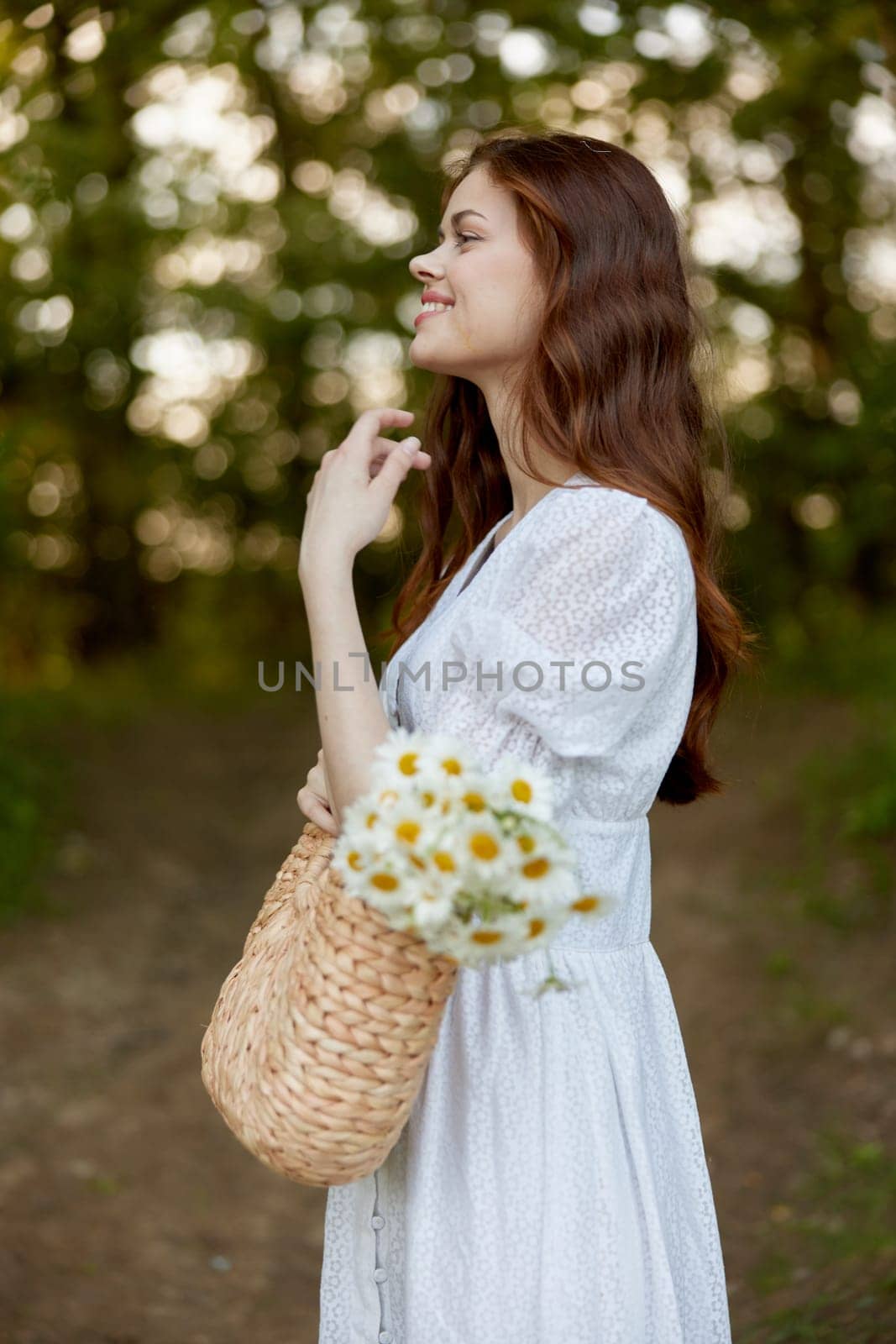 portrait of a beautiful red-haired woman with a wicker bag in her hands, smiling, enjoying a walk in the park. High quality photo