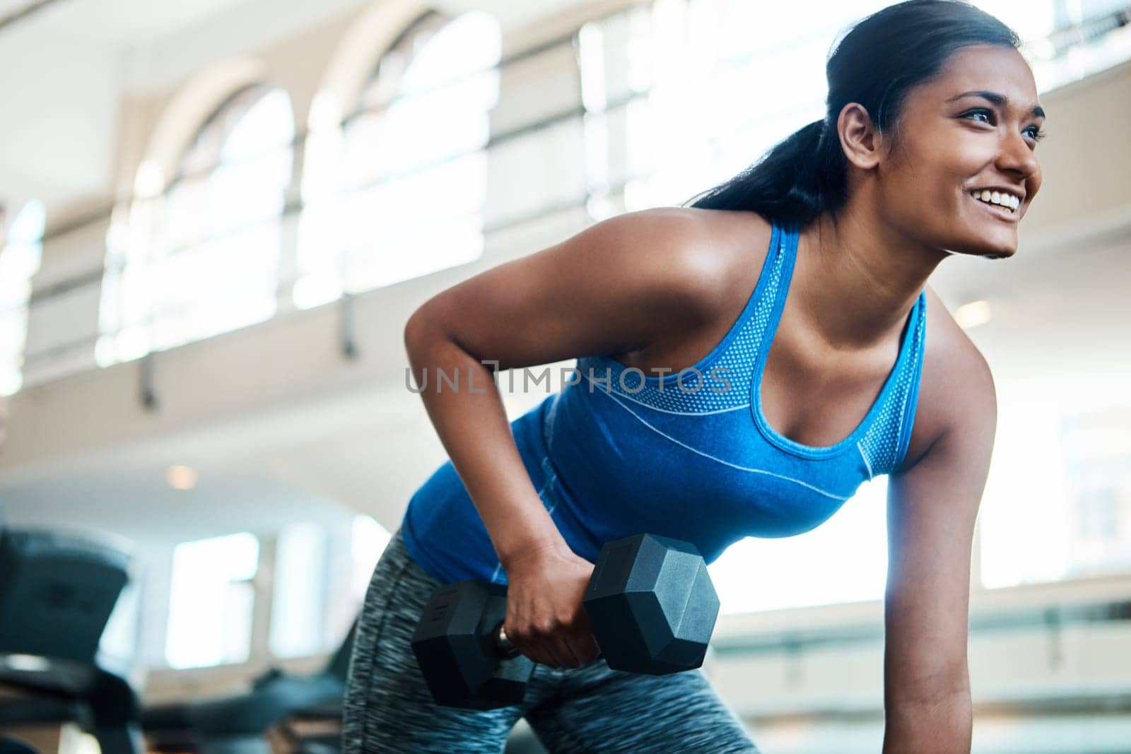 Shes a beauty and a beast. an attractive young woman working out with dumbbells at the gym