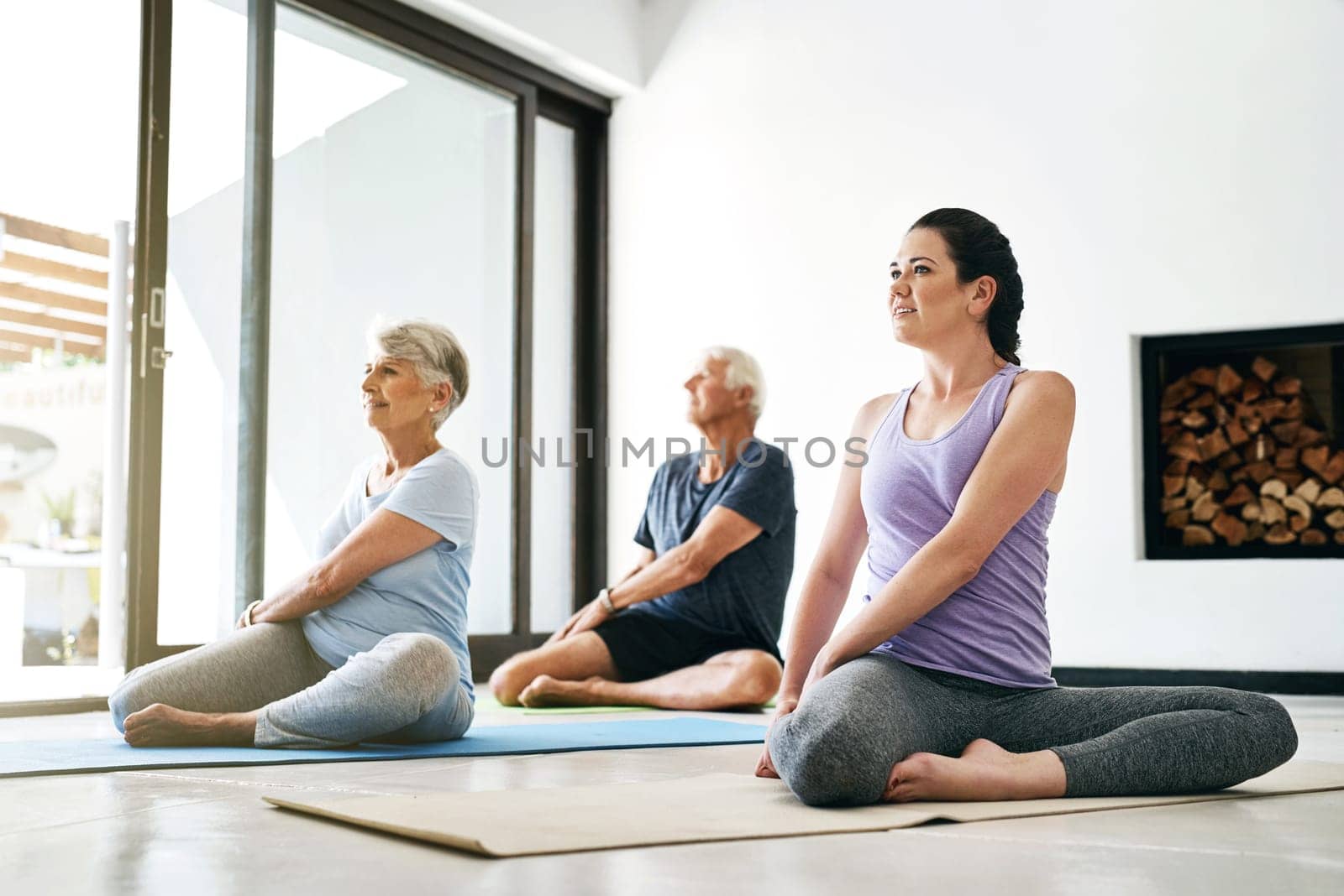 Yoga really is for anyone, at any age. an instructor guiding a senior couple in a yoga class