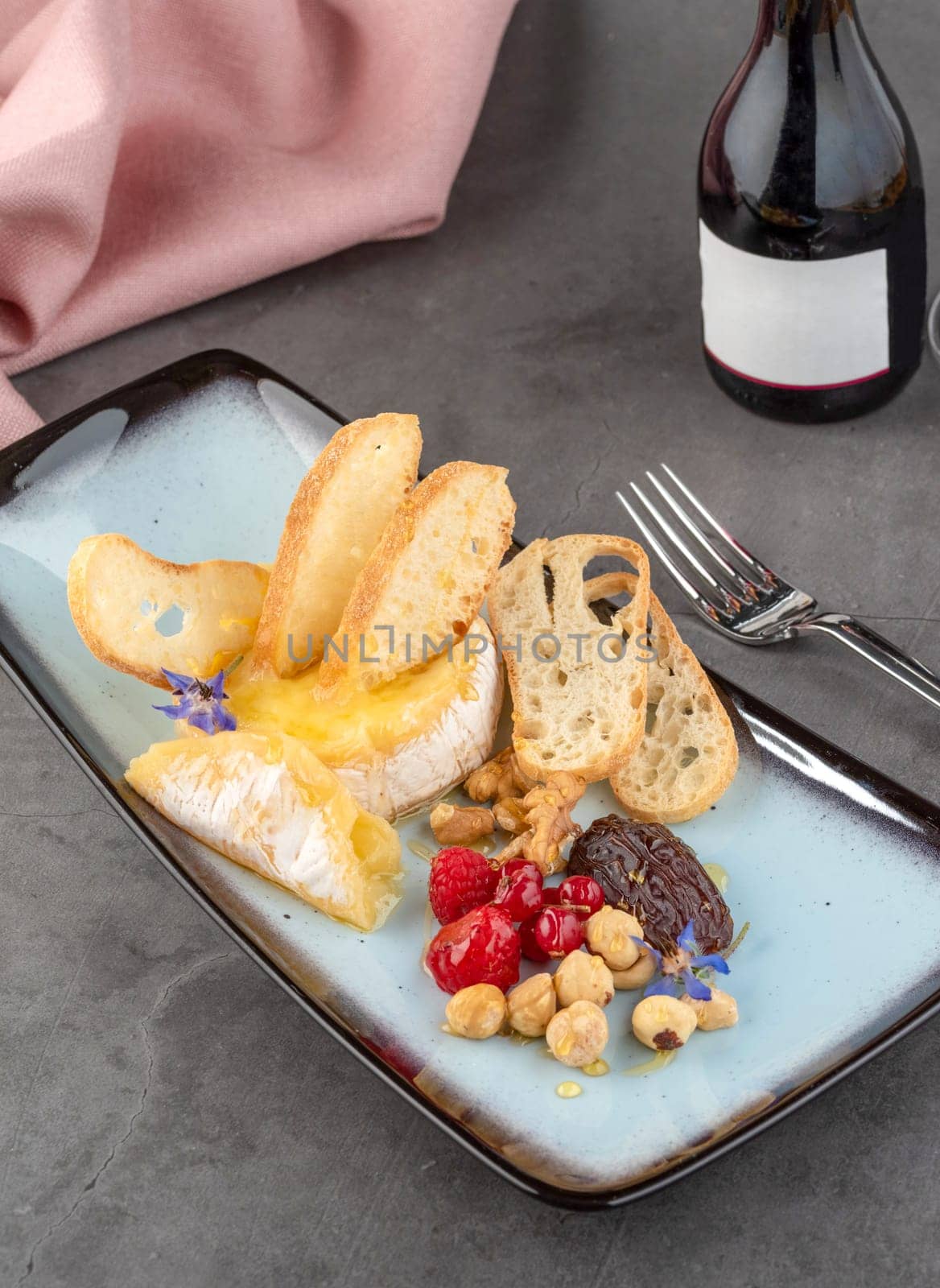 Hot camembert cheese on stone table in fine dining restaurant by Sonat