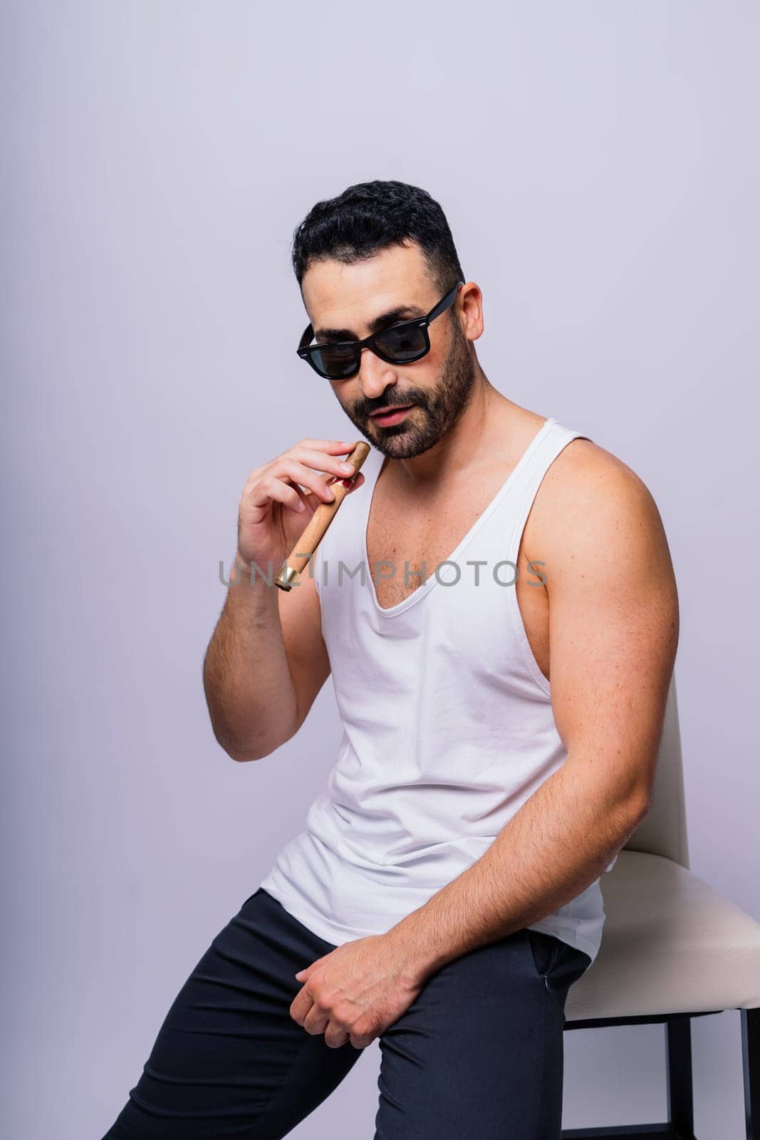 Close-up bearded caucasian man smoking a cigar. Wearing white shirt. Studio portrait by Zelenin