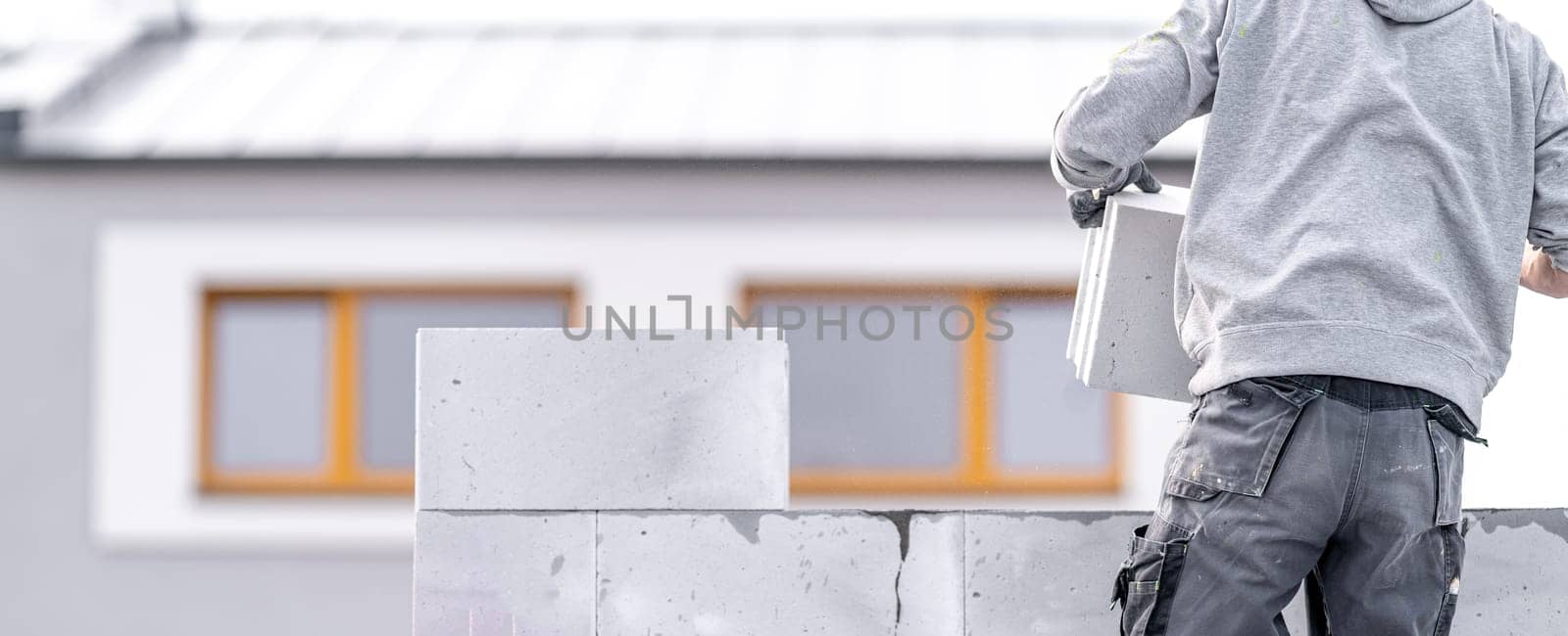 a mason builds a wall from concrete blocks. High quality photo