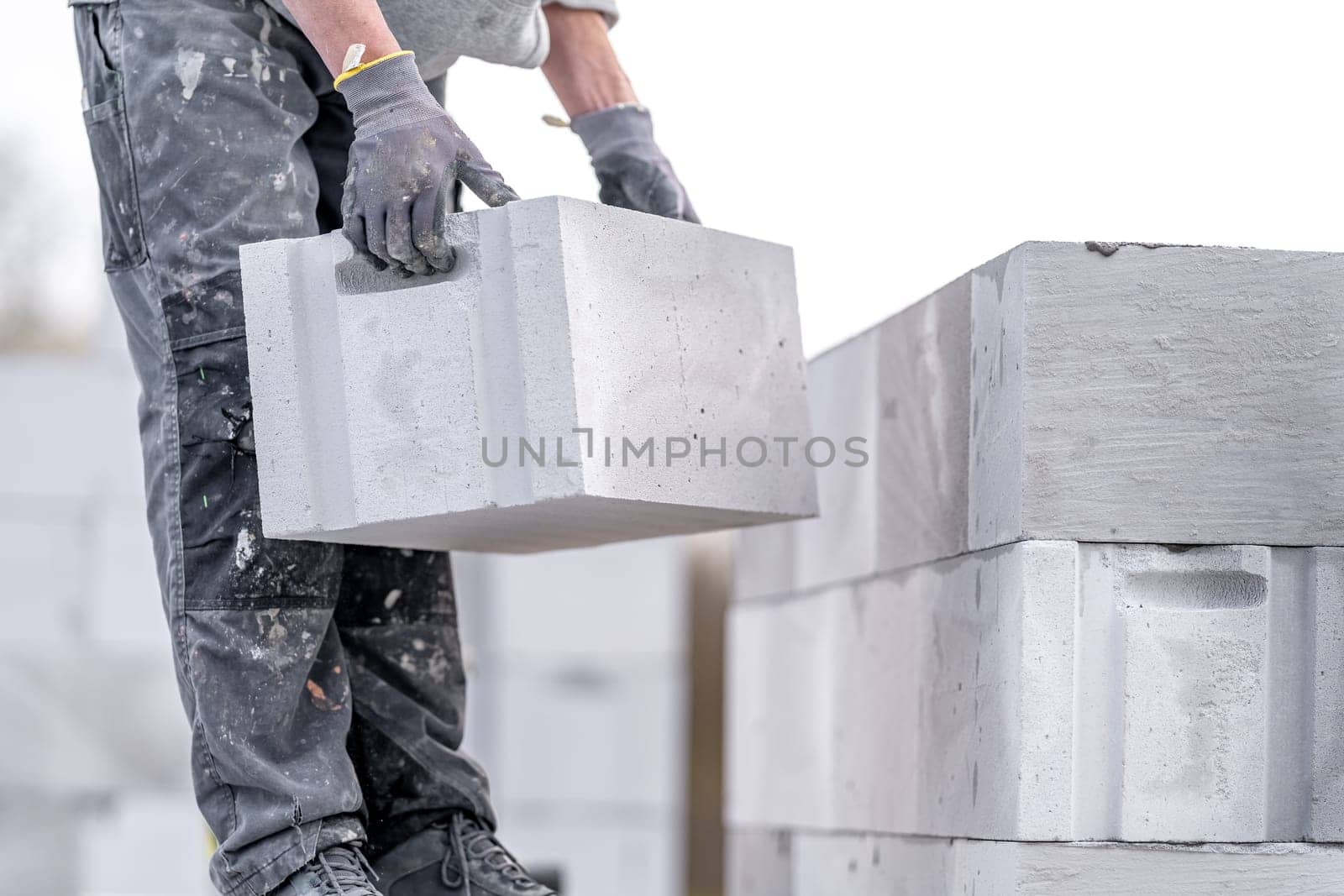 a mason builds the wall of a house from concrete blocks. High quality photo
