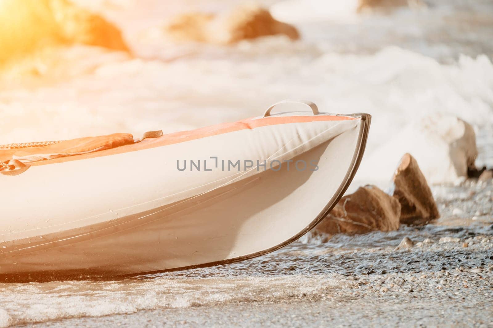 Happy couple kayaks in an inflatable kayak on the sea at sunset. Couple kanoeing in the sea near the island with mountains. People kayaking in life jackets sail. Back view by panophotograph