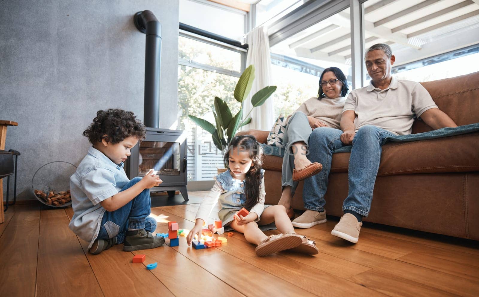 Grandparents, toys and children on floor playing for relaxing, educational game and learning. Child development, family home and happy grandpa, grandmother and kids for quality time, bonding and love.