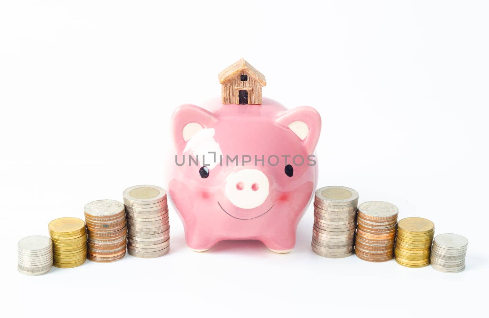 Money coins tower and pink piggy bank on white background.