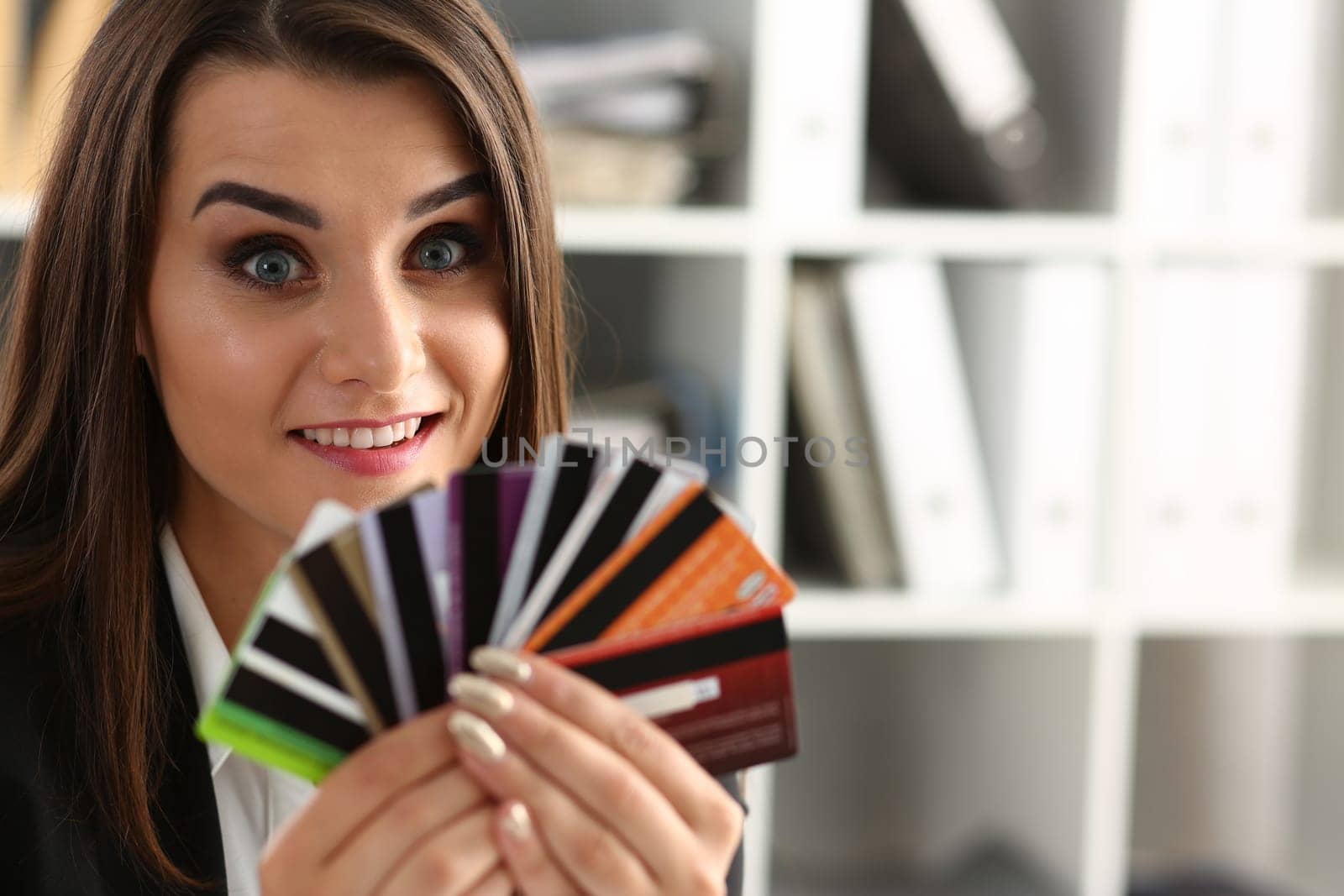 Portrait of young beautiful woman holding bank plastic credit cards. Choice of banking services and approved loan