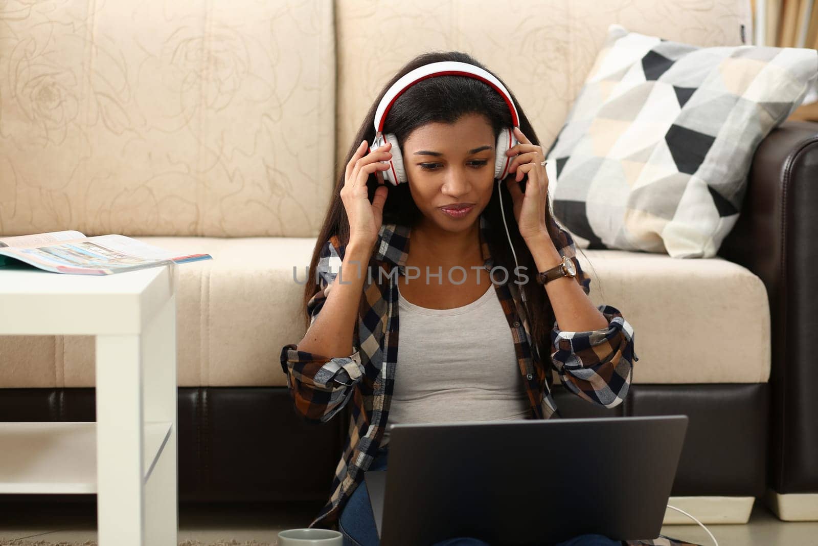 Young African American woman talking on video link in living room at home. Distance learning from home and online communication