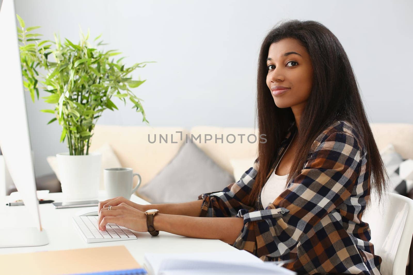 Portrait of happy black business woman at desk typing on computer. Remote work training and information search on Internet